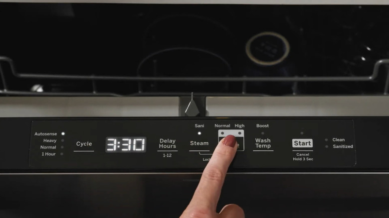 Person making cycle selections on a GE dishwasher