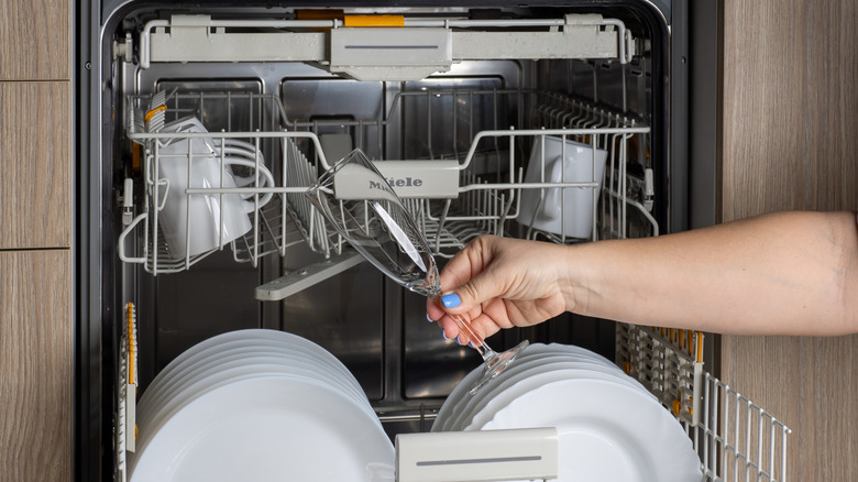 Person unloading a Miele dishwasher