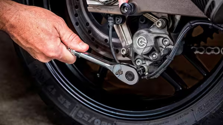 A man working on car brakes with a Husky ratchet