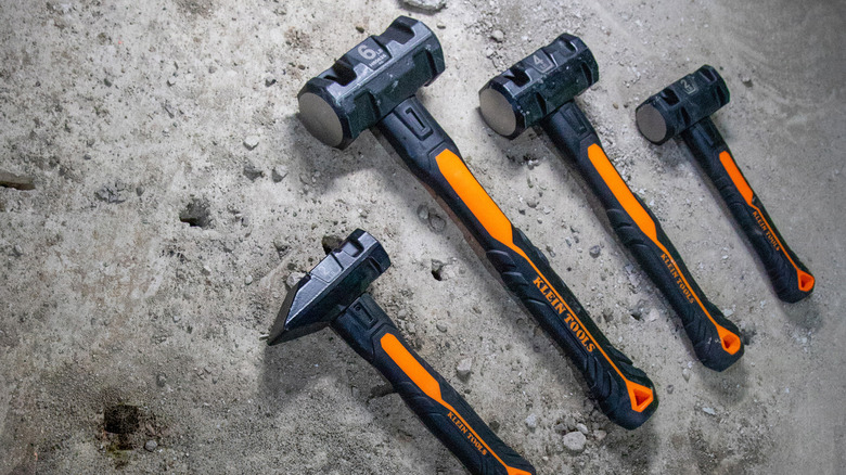 A few Klein Tools hammers arranged on a stone floor