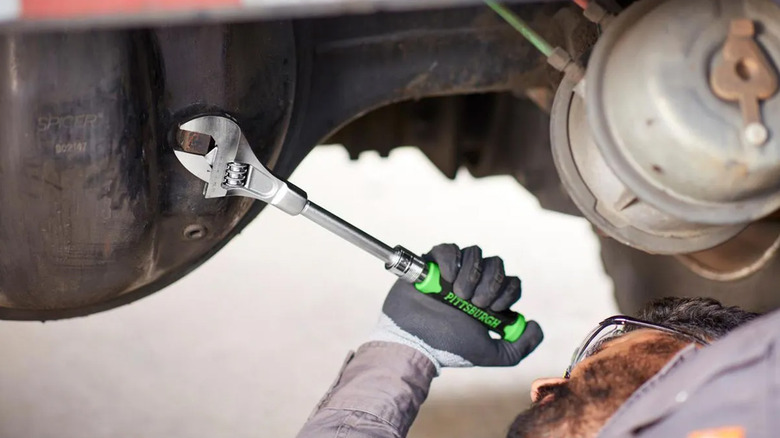A mechanic using a Pittsburgh wrench to work on a car