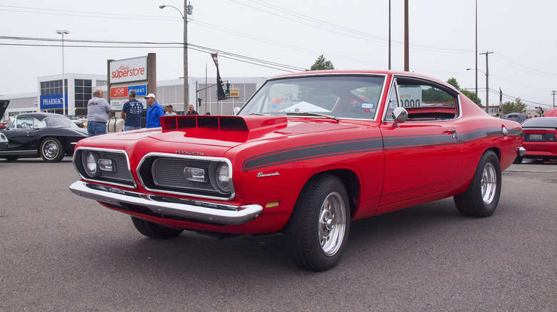 A red Plymouth Barracuda in a parking lot