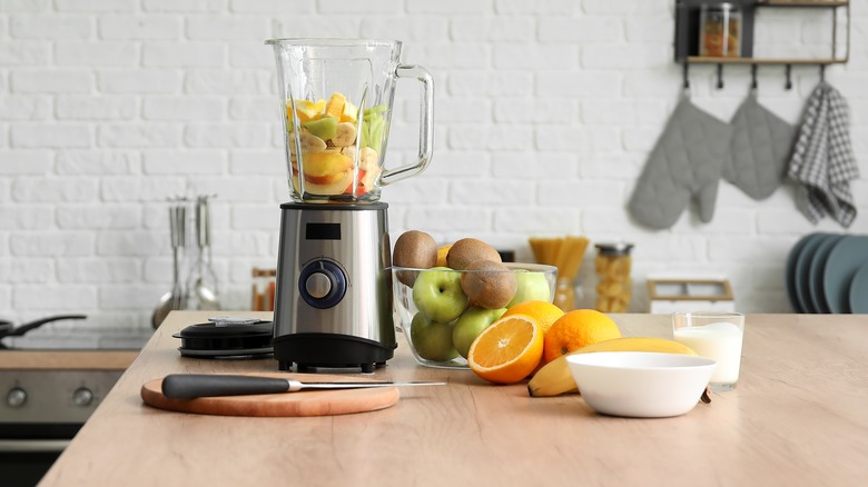 Blender on a counter with fruit