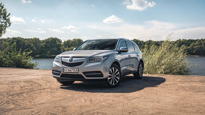 Grey Acura MDX parked by river