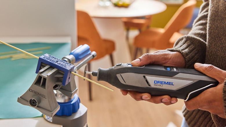 A person using a Dremel to cut wood