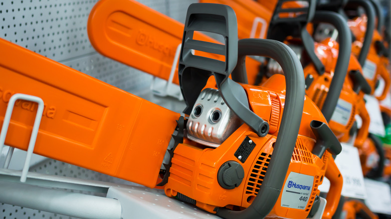 Many orange chainsaws brand Husqvarna on store shelves