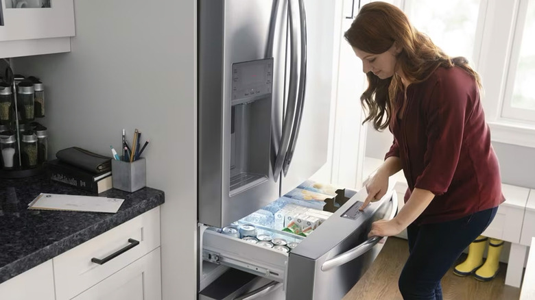 A woman looking into the freezer of a Frigidaire fridge