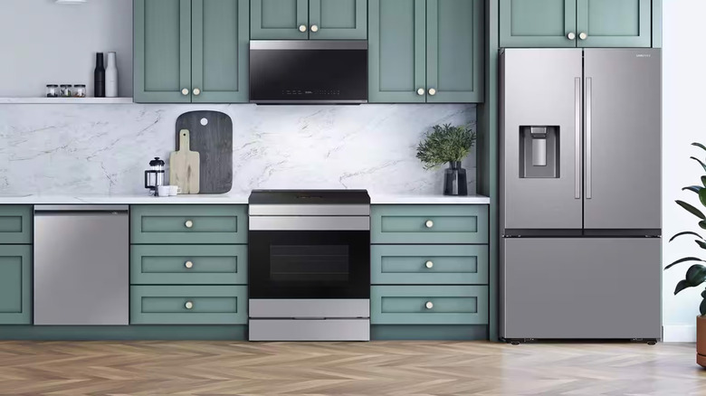 A kitchen with green cabinets featuring Samsung appliances