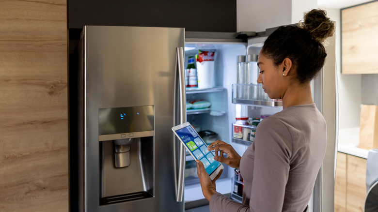 woman standing in front of refrigerator