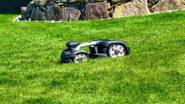 A Husqvarna Automower 435 iQ AWD on a bright green lawn.