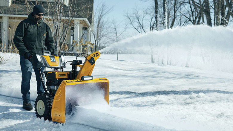 A person uses a Cub Cadet snow blower