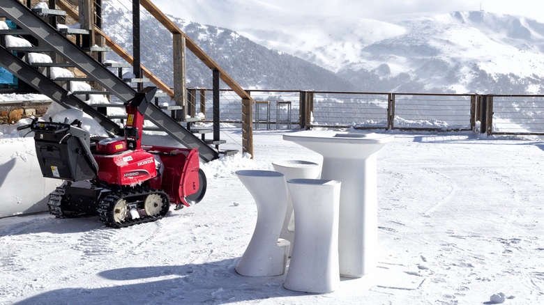 A Honda snow blower in the snow in front of a house