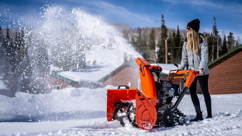 A person operating an Ariens snow blower