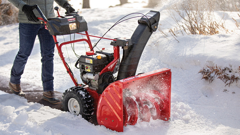 A person using a Troy-Bilt snow blower