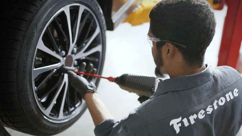 Firestone technician mounting a tire