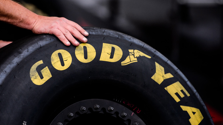 Hand on a Goodyear tire