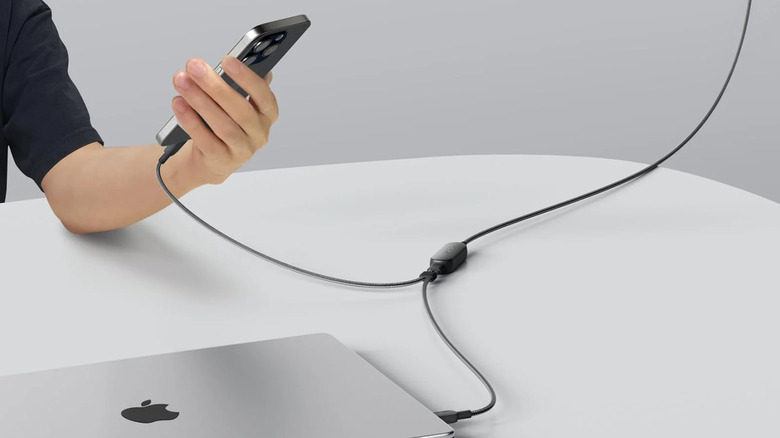An Anker 2-in-1 USB-C cable connects with a smartphone and a laptop.