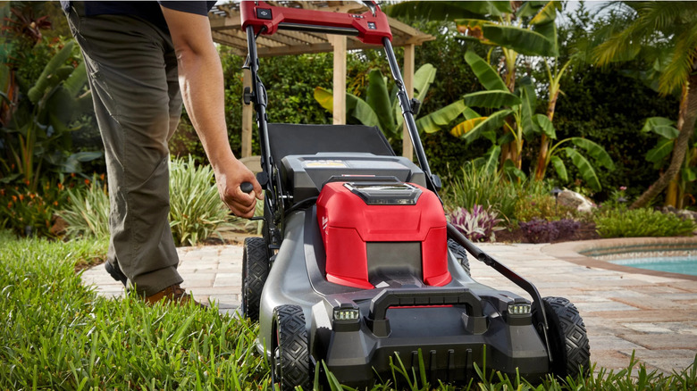 The M18 Fuel 21-Inch Self-Propelled Dual-Battery Mower being controlled by a person