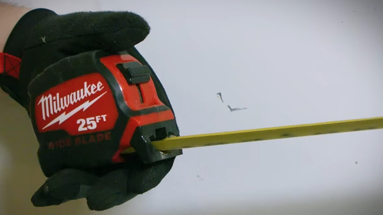 person holding measuring tape in hand