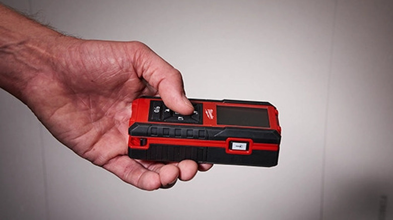 Person holding laser distance meter