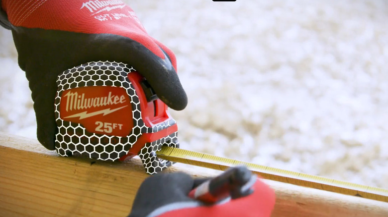 Person using a tape measure on lumber