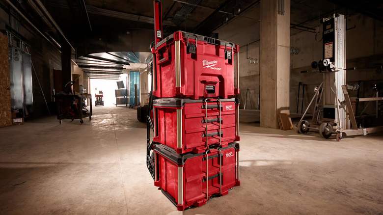 Various Milwaukee Packouts toolboxes stacked on one another in a large empty building