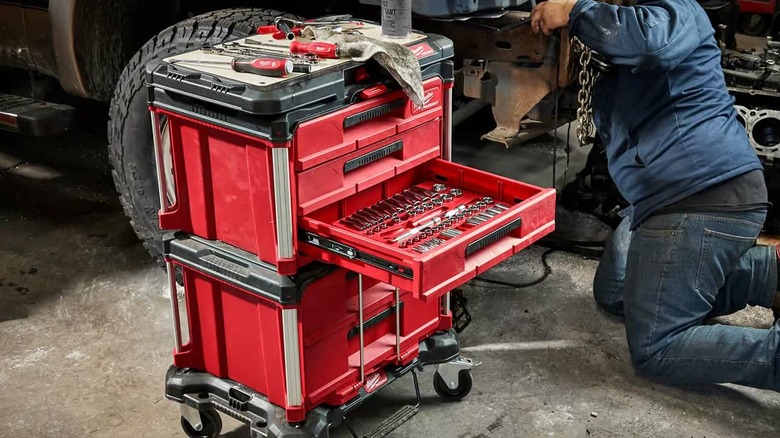 The Packout 3-Drawer Tool Box stacked on top of the Packout 2-Drawer, one drawer is open and contains mechanics tools