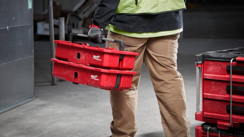 A person carries two Packout Tool Tray stacked on top of each other