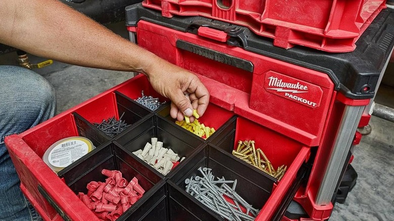 A Packout 2-Drawer Tool Box with the bottom drawer open, a person is taking some wire nuts
