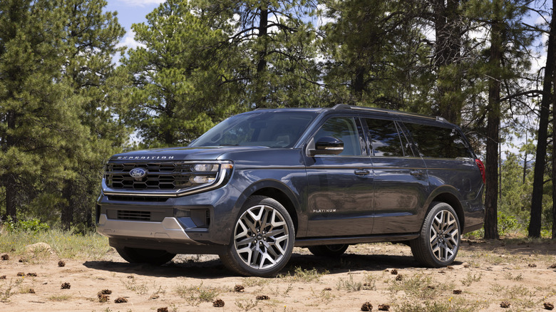 Blue 2025 Ford Expedition SUV seen parked in a forest from front left