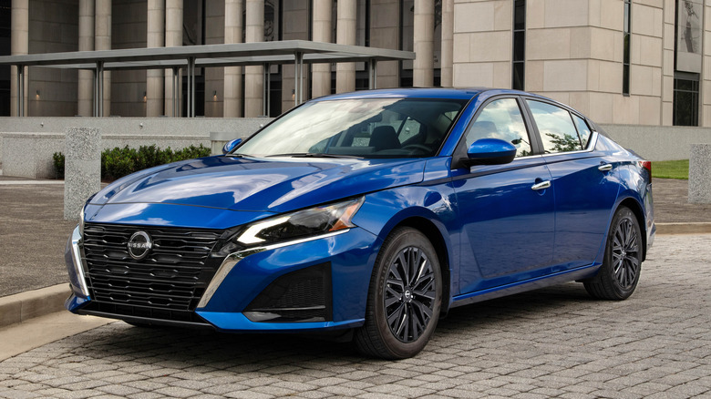 Blue Nissan Altima sedan parked in front of a building