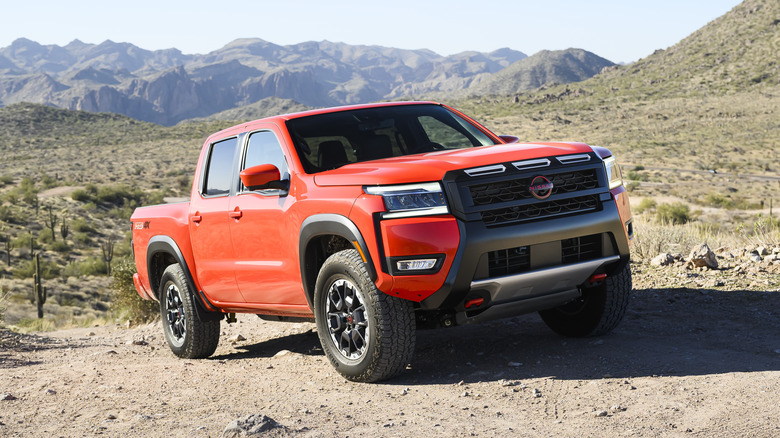 Red Nissan Frontier truck parked in the desert