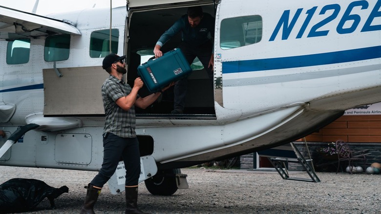 Pelican suitcase being packed onto a plane