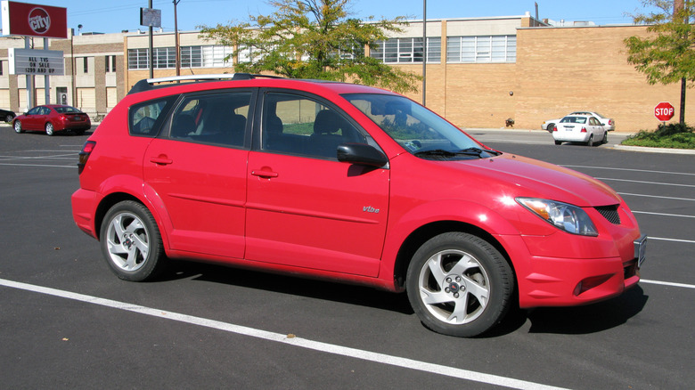 A red Pontiac Vibe at a parking lot, front 3/4 view