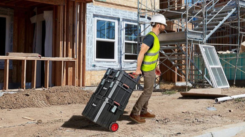 Man rolling Bauer toolboxes on construction site