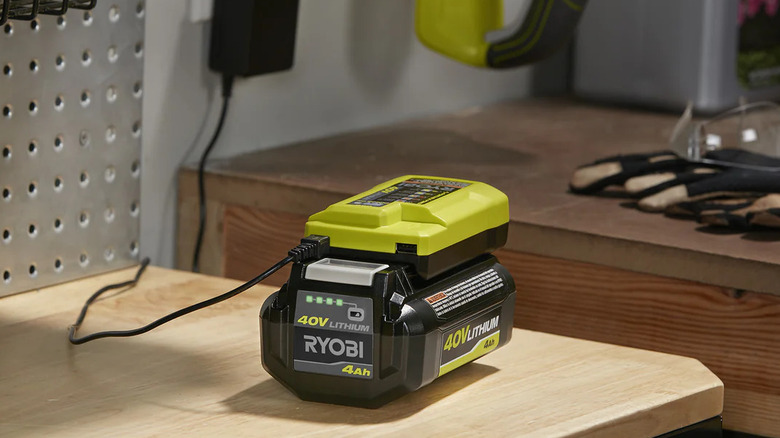 A Ryobi 40V Charger with USB Port with a battery inside, on a wooden table