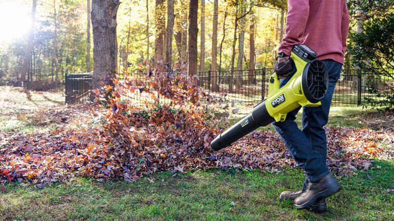 A person using a 450 CFM 18V Ryobi leaf blower