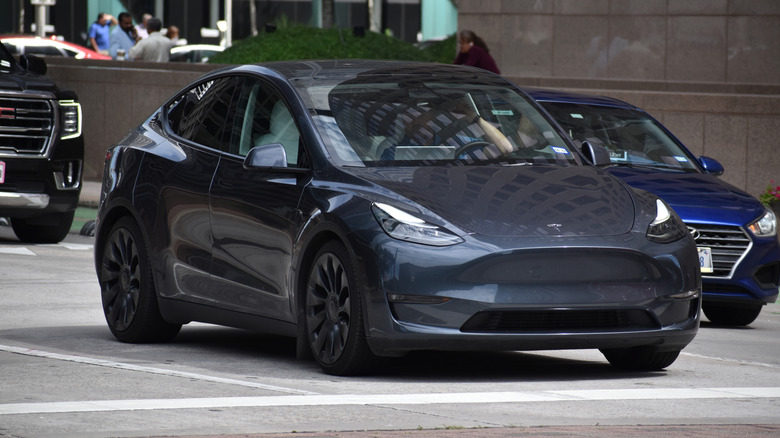 A gray Tesla Model Y driving