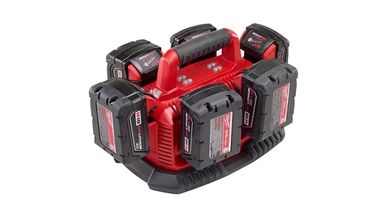 A battery charger with six batteries on it on a white background.