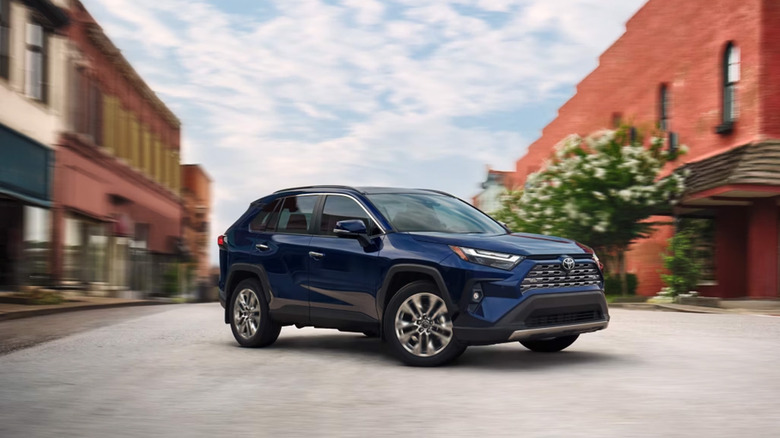 A blue Toyota Rav4 turning around on a road