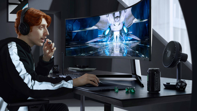 A person playing a sci-fi video game on a curved monitor.