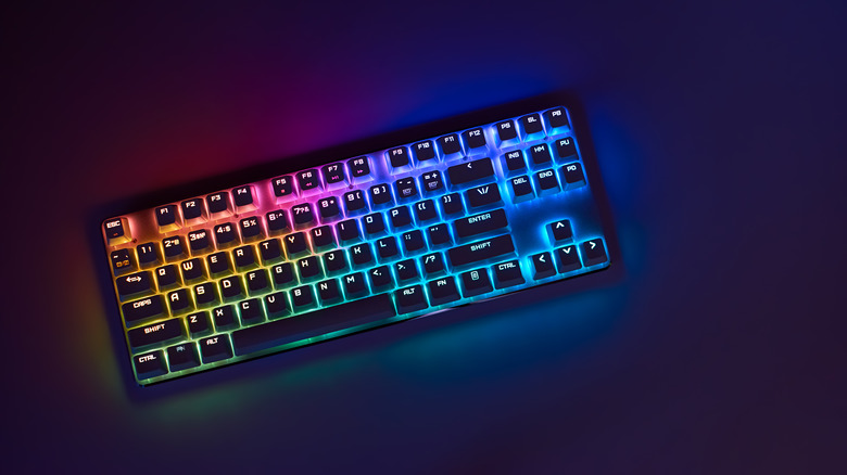 Mechanical RGB keyboard sitting on table in dark room 