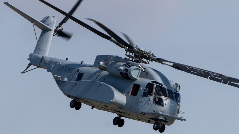 A Sikorsky CH-53K King Stallion flying over cloudy skies