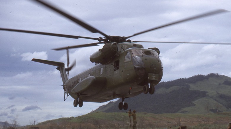 A Marine Corps CH-53 Sea Stallion lifting supplies from a landing zone
