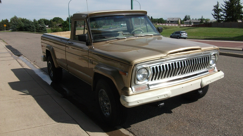 Beige 1974 Jeep J-20 pickup parked at roadside