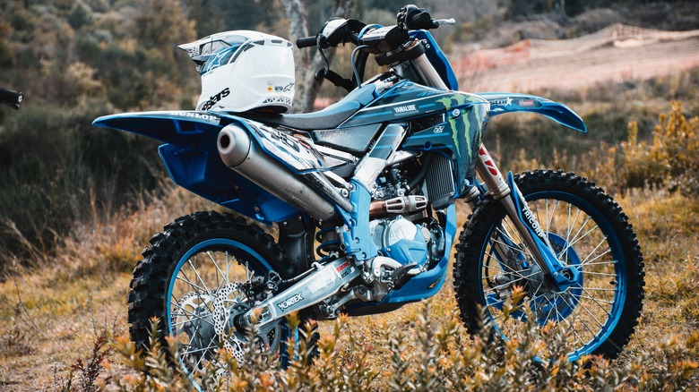 Dirt bike with a white helmet on the seat on a trail