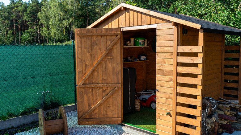 A wood garden shed with the door open
