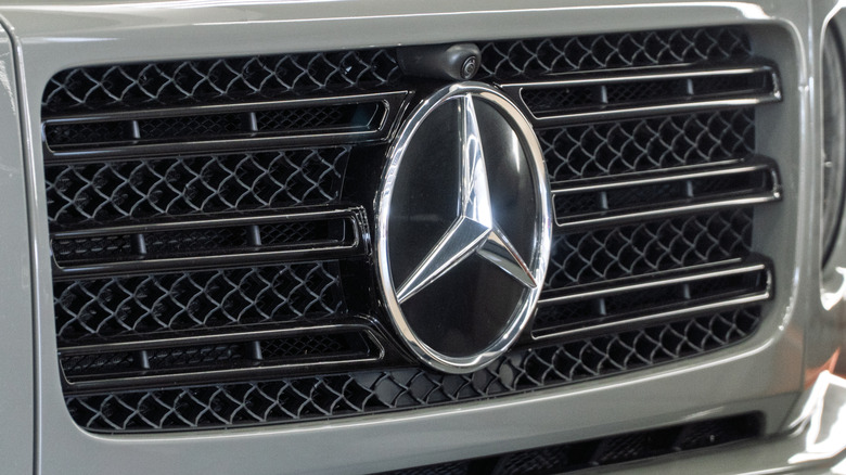 Front grill of gray Mercedes Benz G63 AMG showing badge