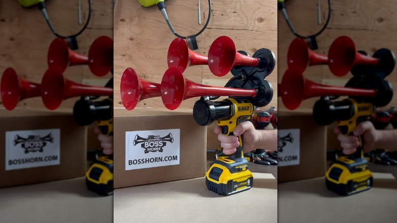 A DIY train horn in red attached to a DeWalt impact drill.