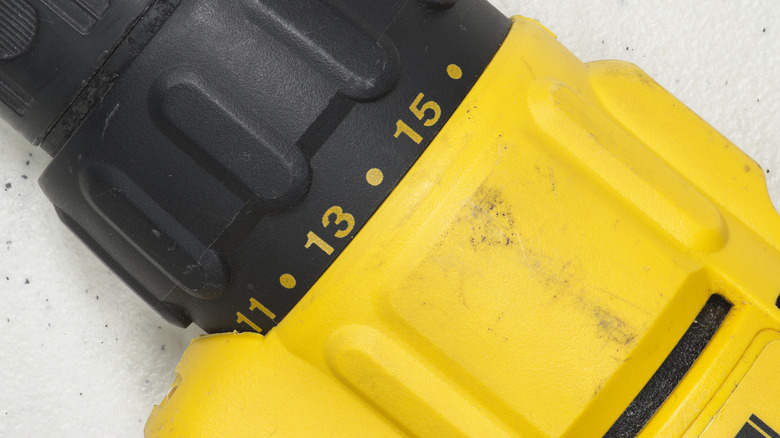 A close-up of a yellow and black DeWalt impact drill showing dirt and labelling.